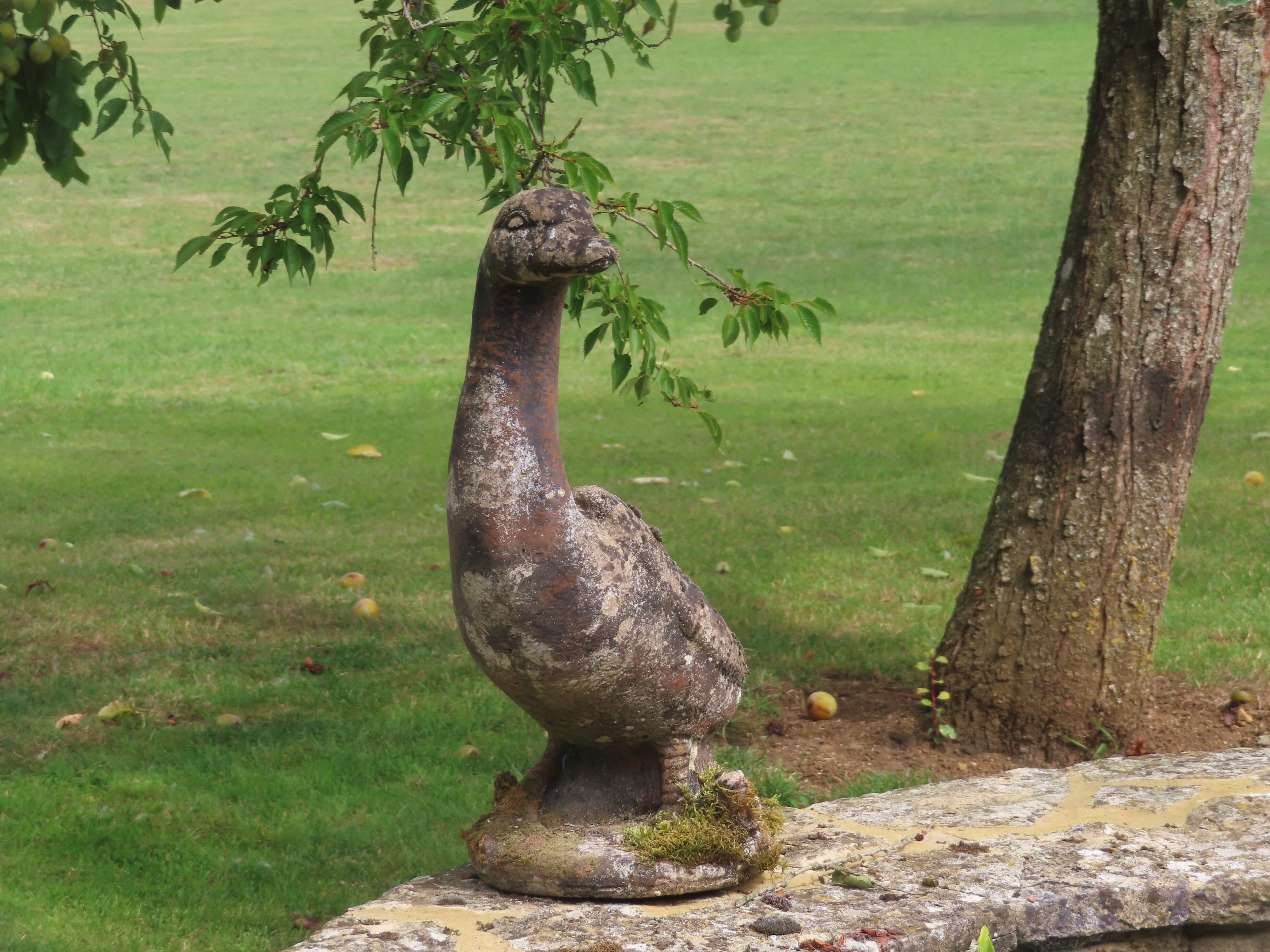 old-stone-statue-of-a-duck-in-a-cotswolds-garden